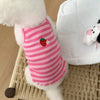 Pink-weiß gestreiftes Kühlvest für Hunde neben einem weißen gesteppten Kissen.