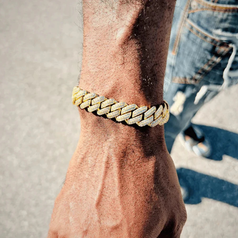 A close-up of a hand wearing an iced-out Cuban link bracelet with rhinestone pavé on the wrist.