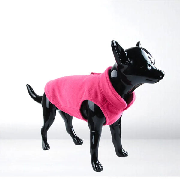 A black dog figurine wearing a bright pink soft fleece coat.