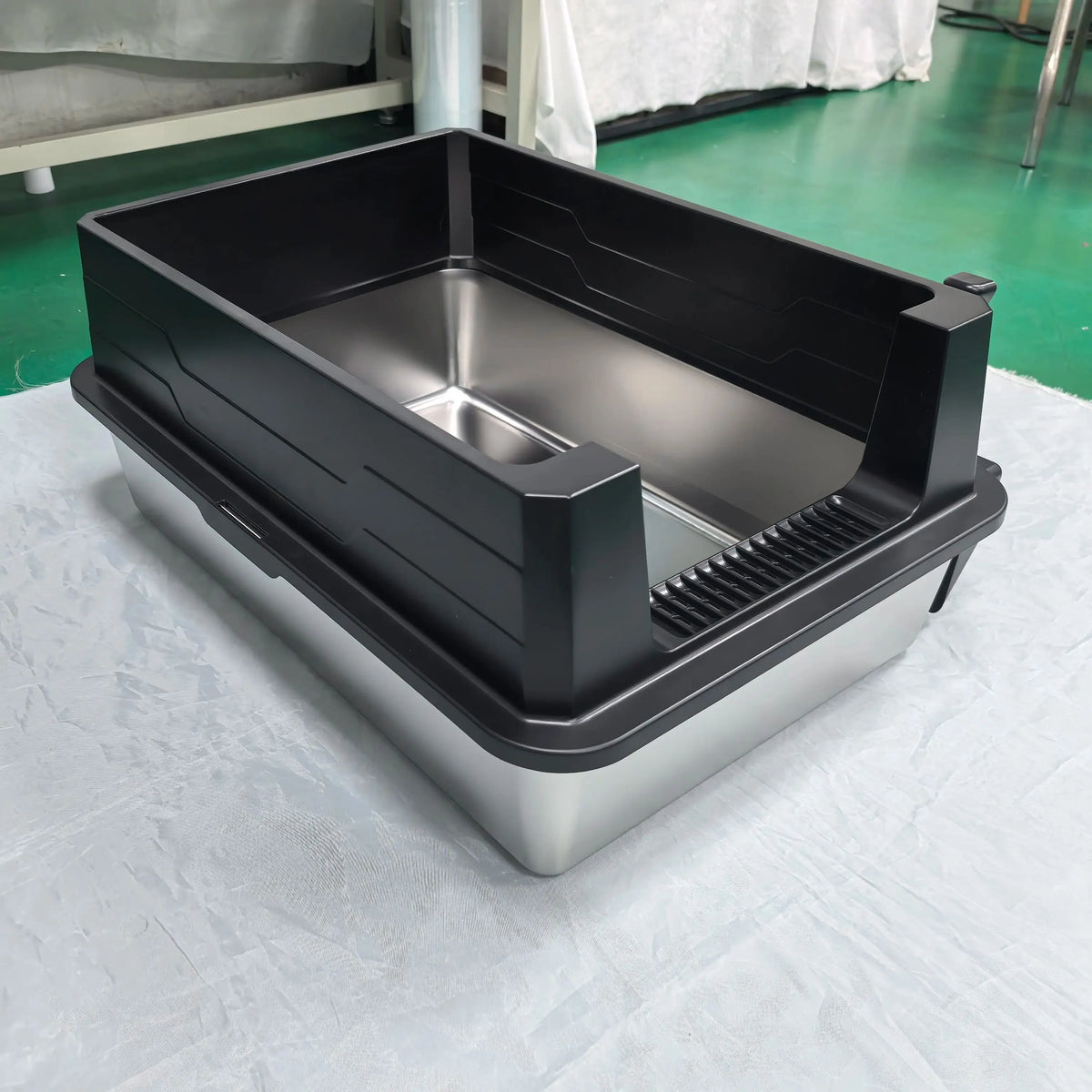 Litière en acier inoxydable noir et argent, extra-large avec design incliné.
