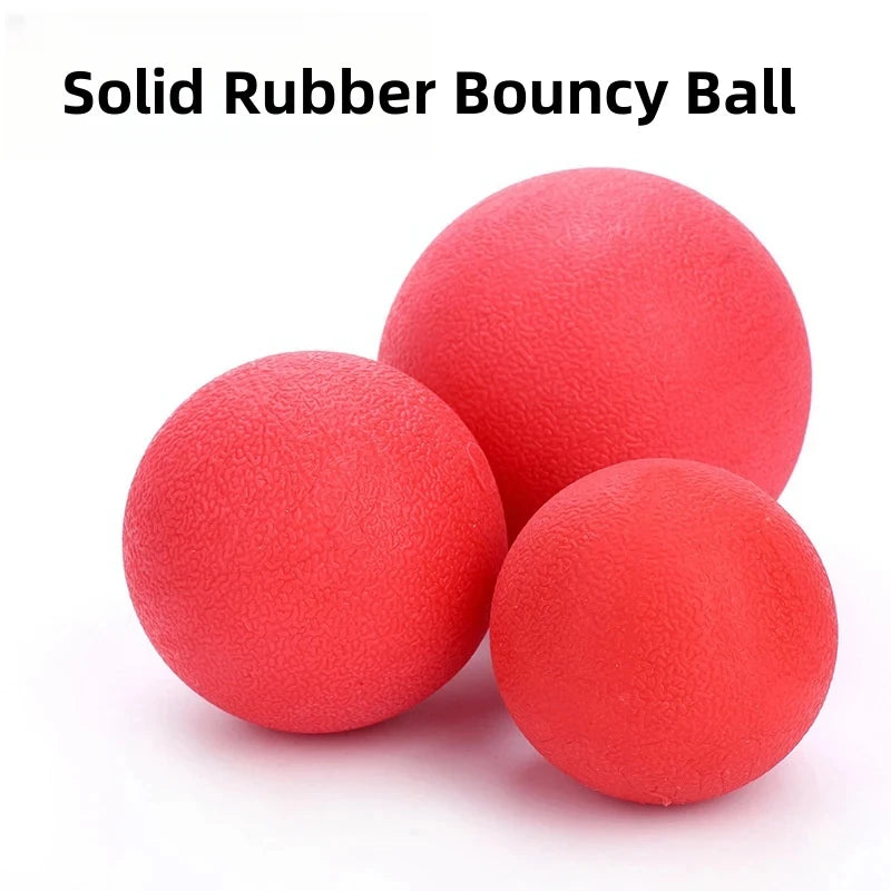 A close-up view of a bright red solid rubber bouncy ball resting on a white surface.