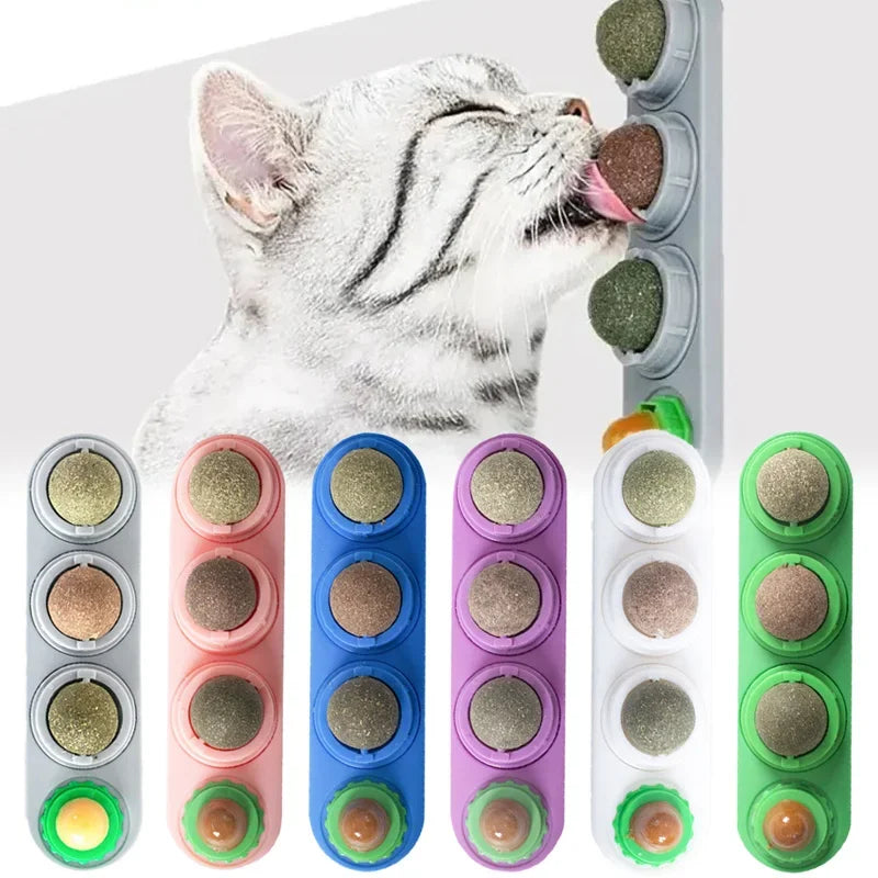 A cat is licking a rotating catnip ball toy with various colored balls.