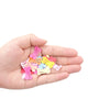 A hand holds a collection of multi-colored dog hair clips for pet grooming.