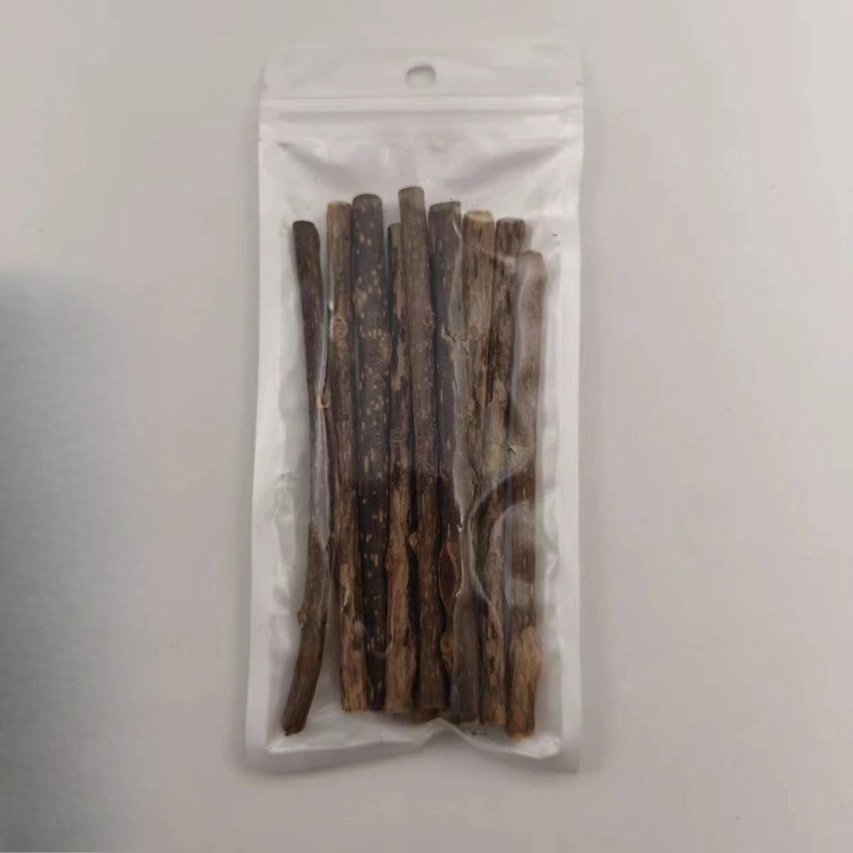 Klare Plastiktüte mit mehreren natürlichen Holz-Kaugummisticks für Katzen.