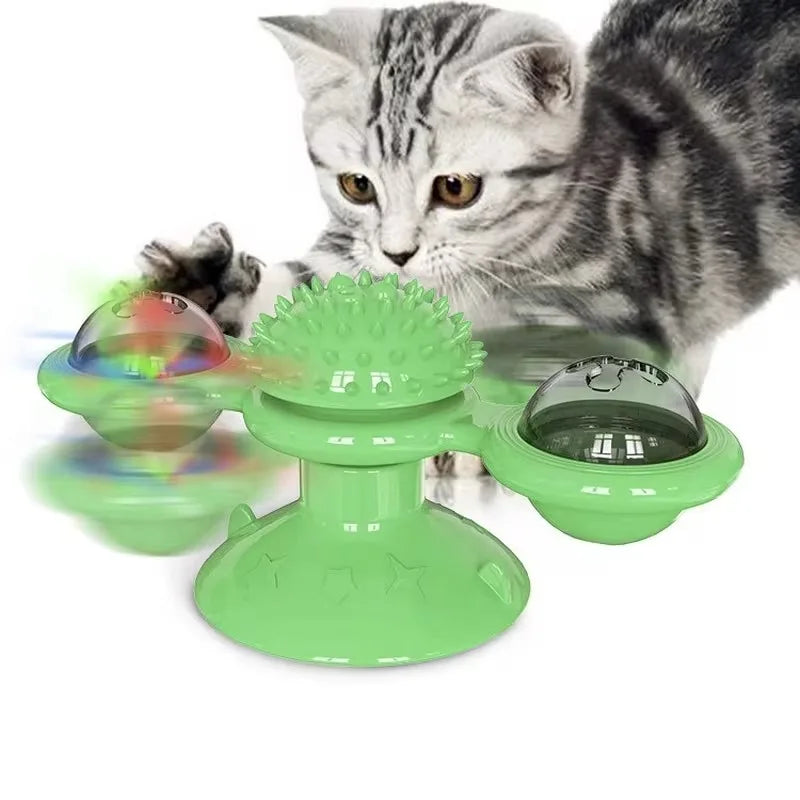 Un chat tigré interagit avec un jouet en forme de moulin à vent vert et tournant pour jouer.