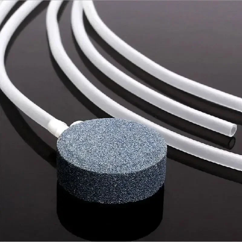 A round, speckled silicone tube with a connector is shown alongside several white flexible tubing strands.