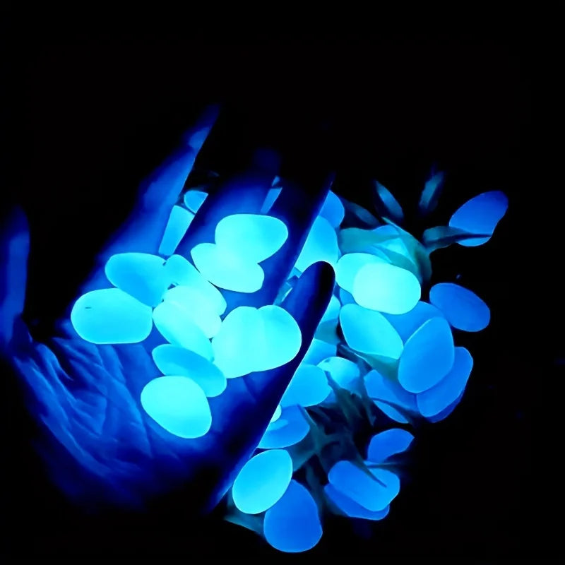 A hand holds glowing blue stones that are used as decorative elements for planters and vases.
