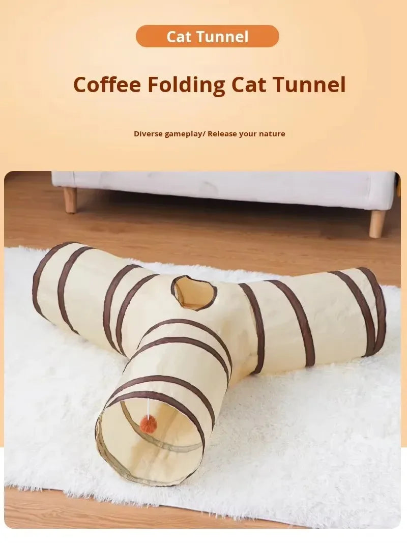 A beige folding cat tunnel with brown stripes is shown lying on a white fluffy towel.