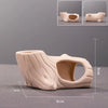 A beige ceramic aquarium shrimp hideaway cave with a natural, sculpted texture.