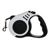 A white and black retractable dog leash with a black handle and three markings.