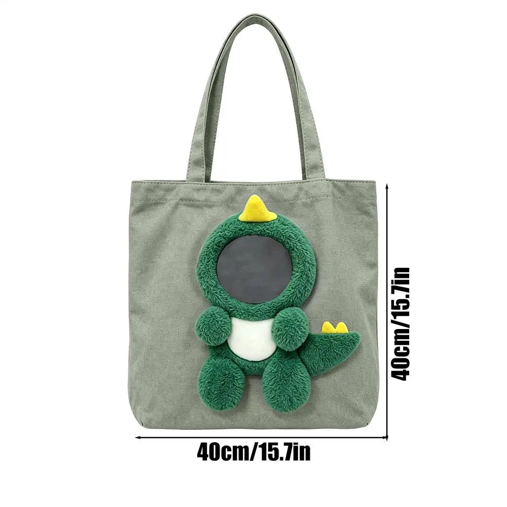 A gray canvas pet carrier bag featuring a green, textured animal design with yellow accents.