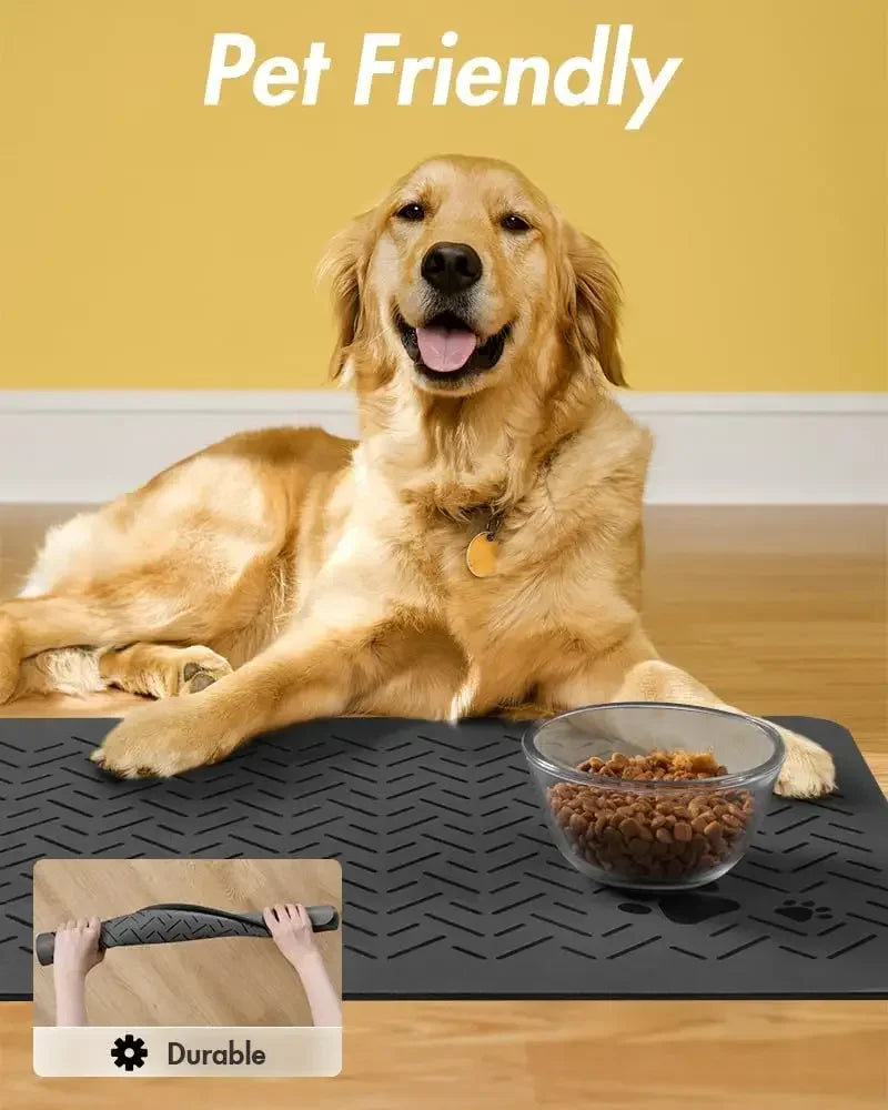 A golden retriever lies on a black pet feeding mat with a bowl of dry food on it.