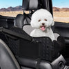 A fluffy white dog is sitting in a black cozy center console car seat inside a vehicle.