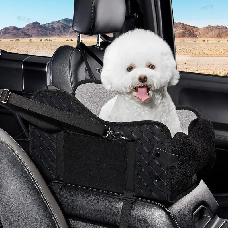 A fluffy white dog is sitting in a black cozy center console car seat inside a vehicle.