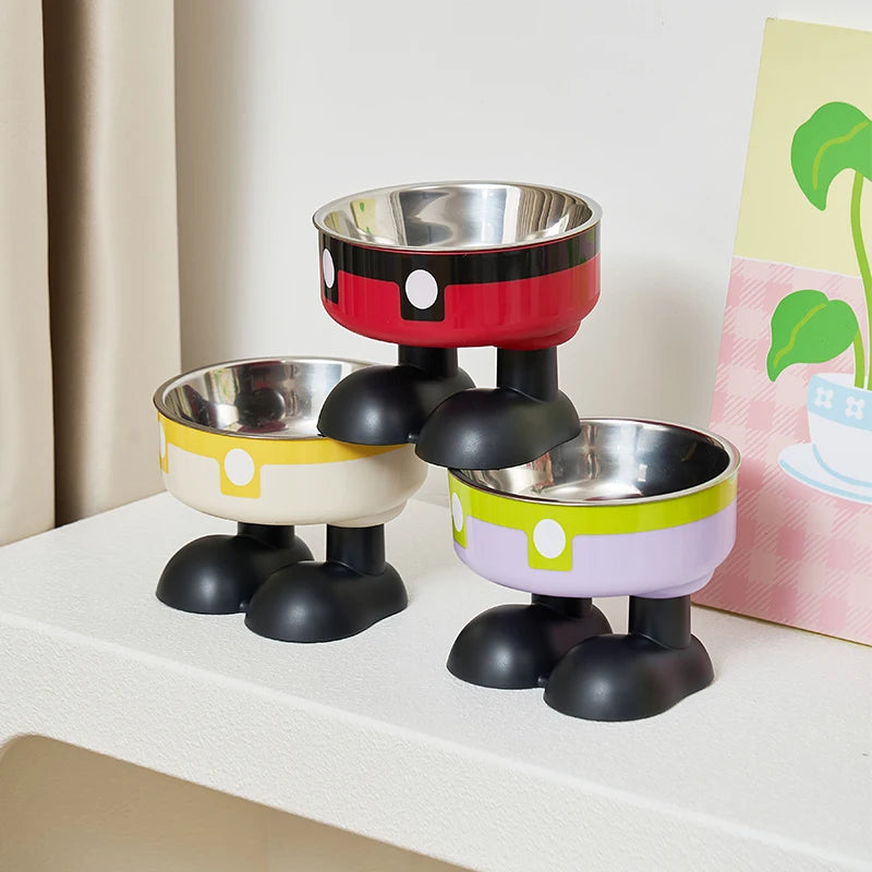 A set of three elevated stainless steel pet bowls in black and colored bases are displayed on a white surface.
