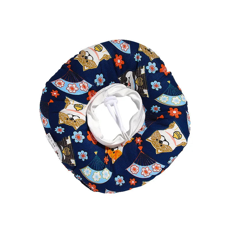 A dark blue fabric collar patterned with gold paw prints and colorful floral designs, used as an anti-lick cone alternative f