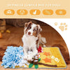 A dog is lying on a yellow blanket with blue and green fabric pieces for sniffing training.