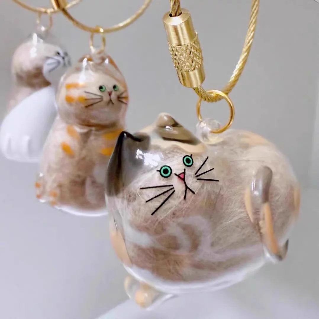 A set of ceramic cat charms with gold-colored chains and clasps, featuring various orange and white tabby cats.