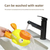A yellow duck-shaped puzzle toy is being washed with water.