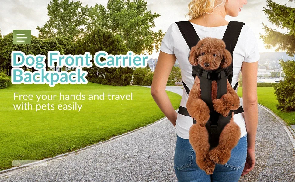 A woman is wearing a black dog front carrier backpack with a fluffy brown puppy while walking on a paved path.