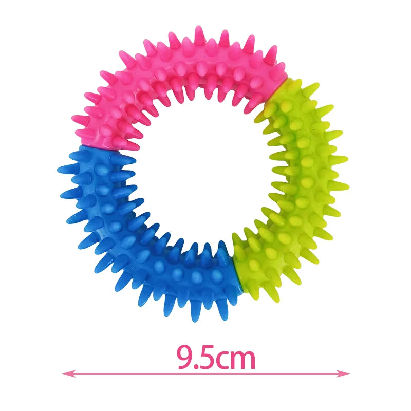 A colorful spiky ring dog chew toy made of pink, blue, and green plastic.