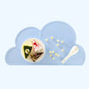 A light blue cloud-shaped silicone pet feeding mat holding small yellow pellets and a spoon.