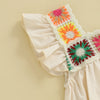 A close-up of a cream colored toddler romper featuring colorful floral embroidery details on the bodice.