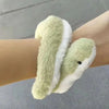 A light green snake plush toy with white stripes is shown wrapped around a person's arm.