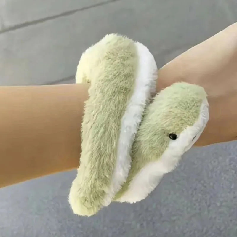 A light green snake plush toy with white stripes is shown wrapped around a person's arm.