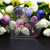 A set of precision hama beads tweezers with various colored beads displayed among fresh flowers.