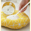 A hand is adjusting a white soft cotton recovery collar for dogs or cats, which is yellow and features a honeycomb pattern.