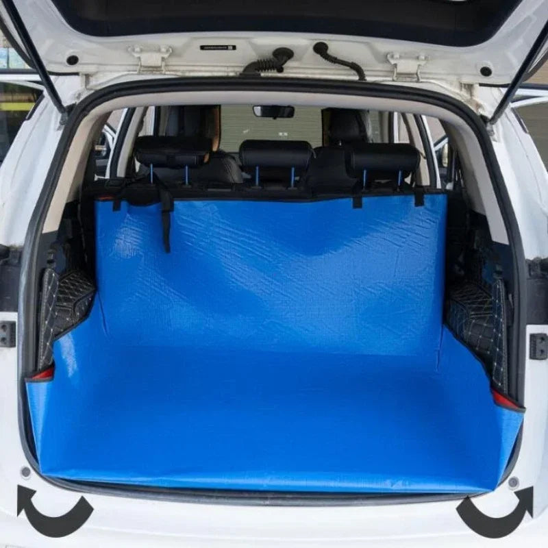 Interior view of a white car trunk showing a blue waterproof mat with a pet barrier installed.