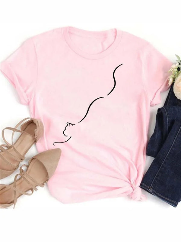 Pink t-shirt featuring a black line drawing of a sleeping cat face and tan sandals.