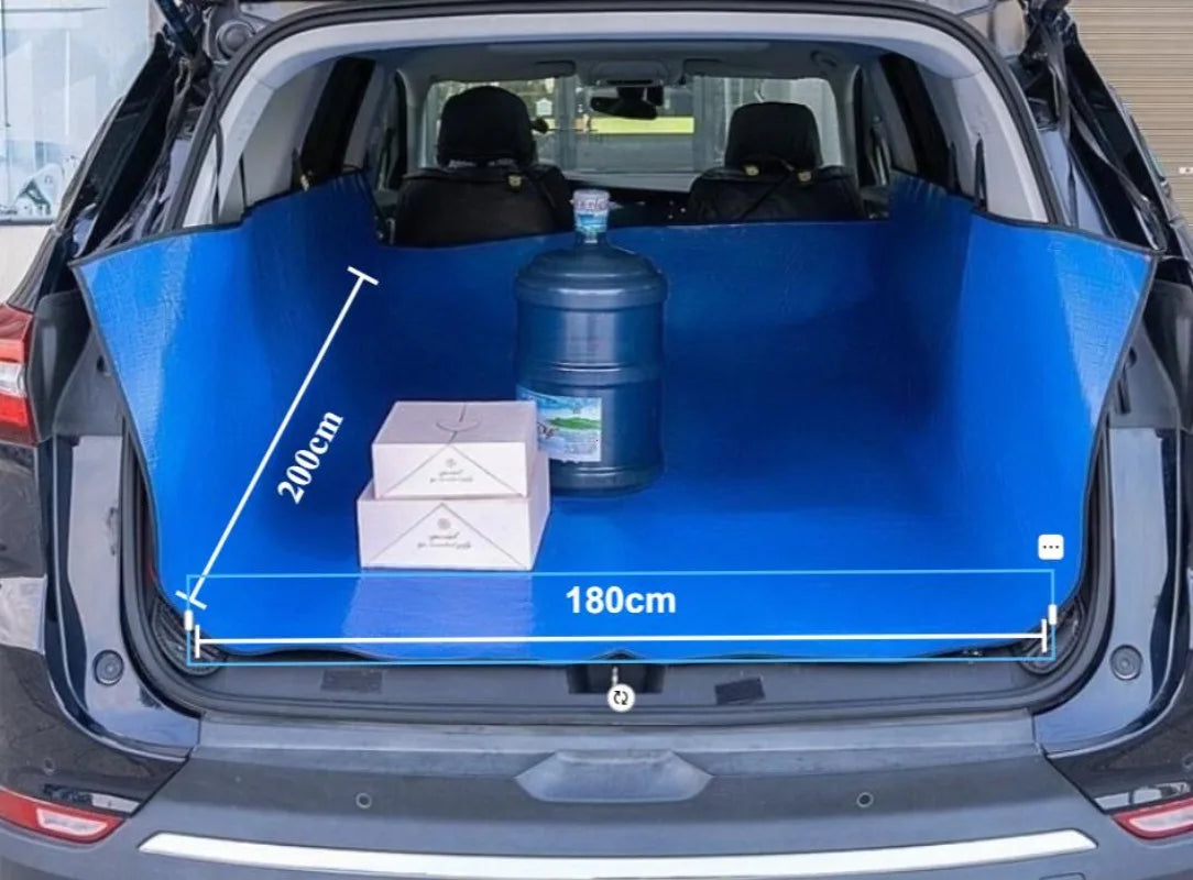 A blue waterproof car trunk mat with a pet barrier is shown inside the trunk of a car.