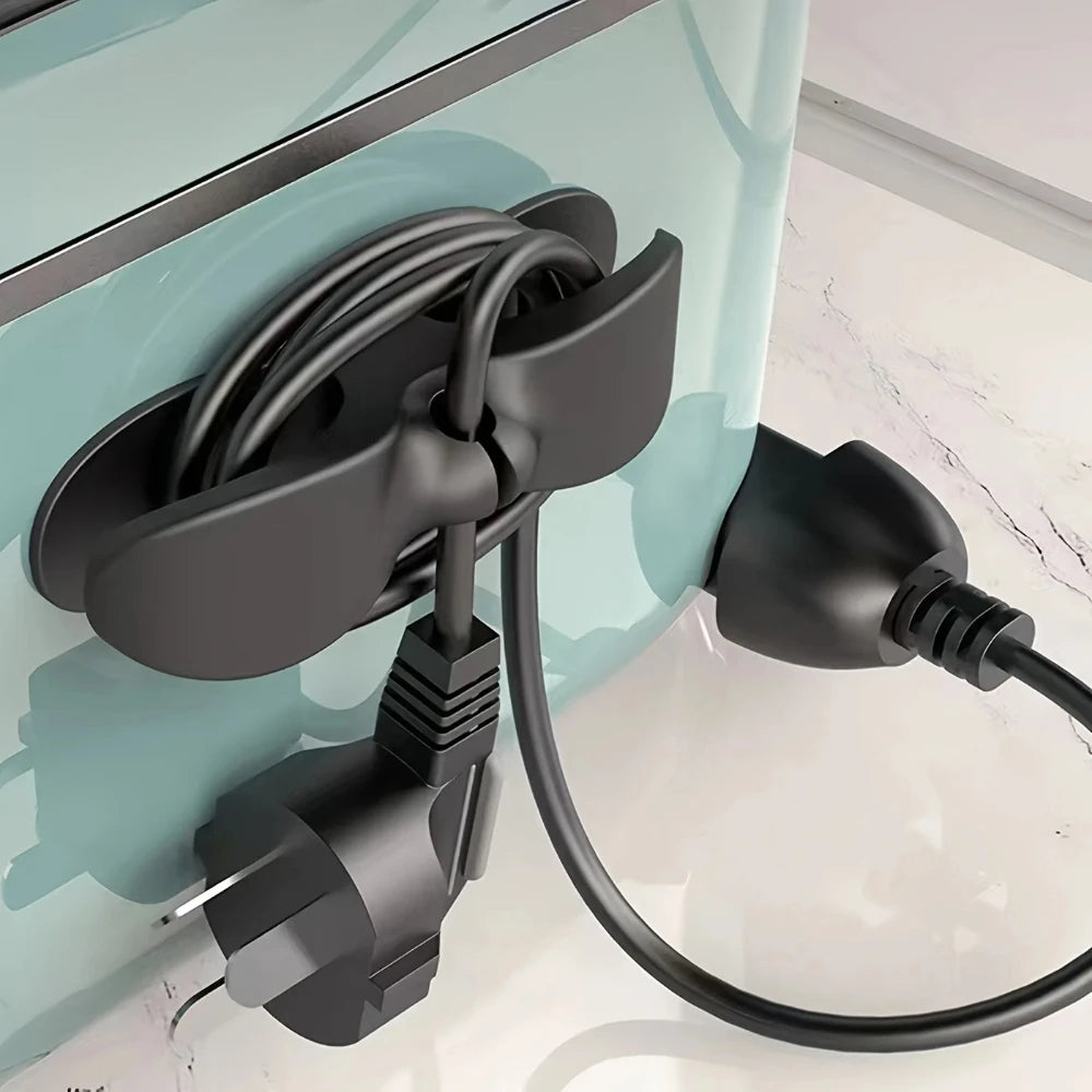 A black heavy-duty silicone cable organizer is mounted on a light blue cabinet, featuring a flexible cord for household wires
