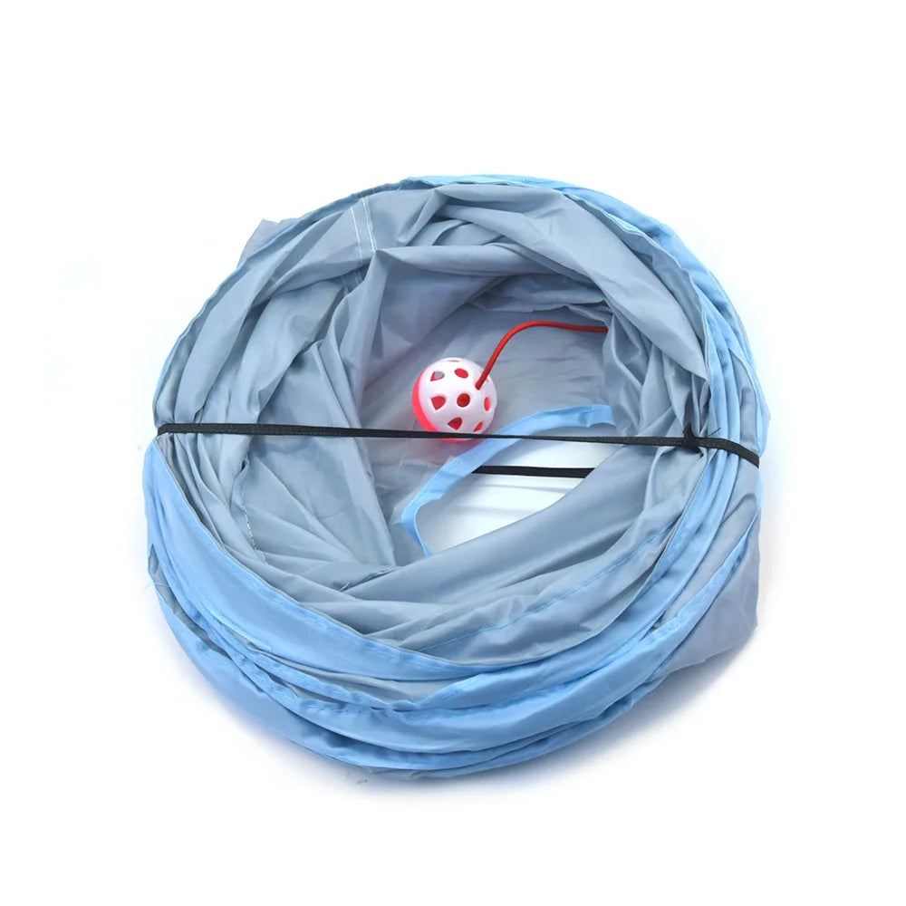A light blue foldable cat tunnel coiled up, featuring a round, red and white speckled peep hole.