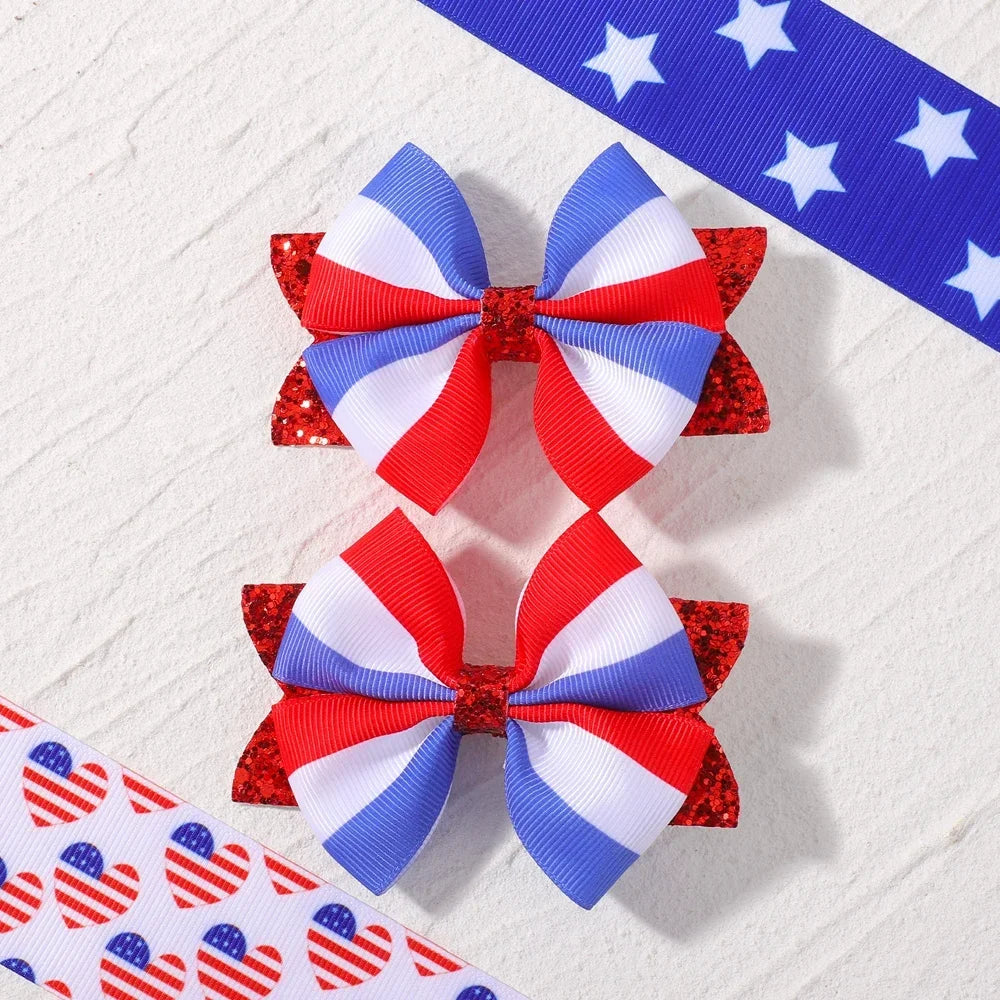 A pair of red, white, and blue ribbon hair bows with clips featuring stars and stripes patterns.