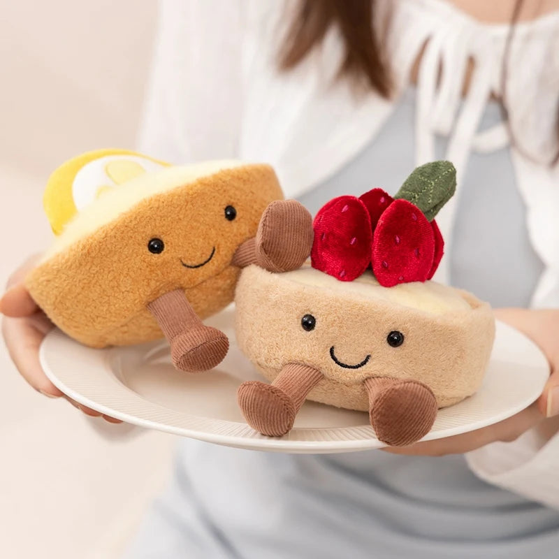 A cute plush toy shaped like a toast sandwich with a yellow slice and brown spread, presented on a white plate.