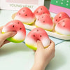 Hands are pressing a pink and green squishy bread fidget toy into a white dish filled with similar toys.