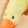 A yellow plush toy shaped like a duck with an orange beak and black eyes.