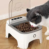 A gray and white cat is feeding from a smart sensor pet feeder designed for timed dispensing.