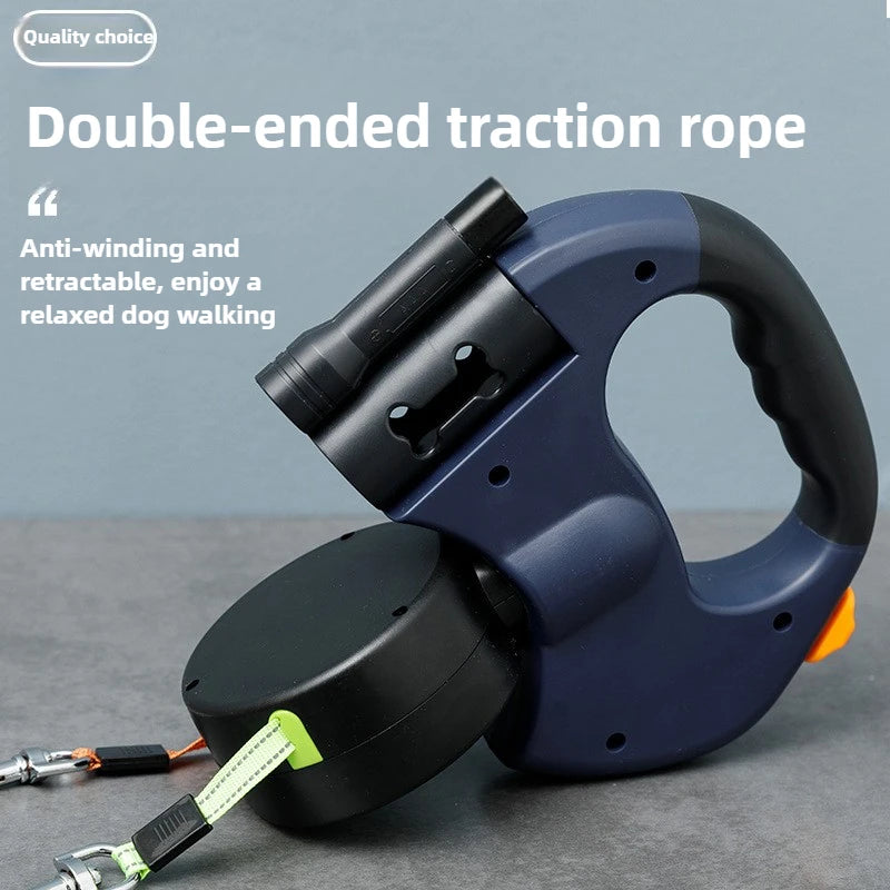 A close-up of a blue double-ended traction rope leash with a black handle and a green cord, resting on a gray surface.