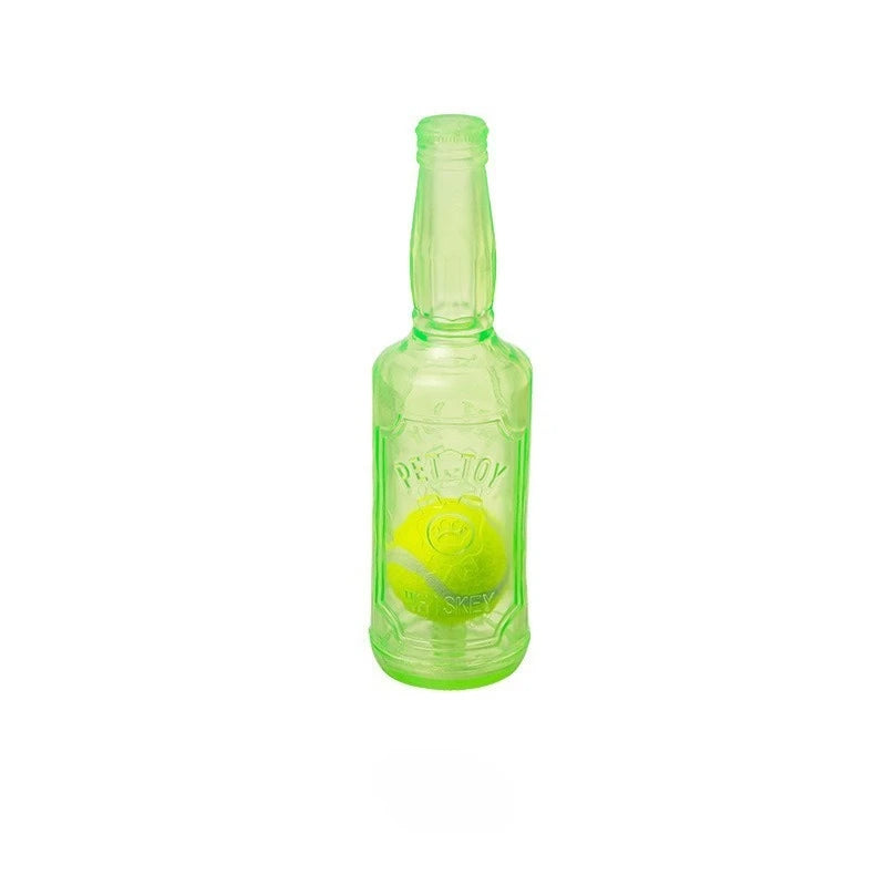 A clear glass bottle filled with green liquid, shaped like a dog chew toy with a tennis ball inside.