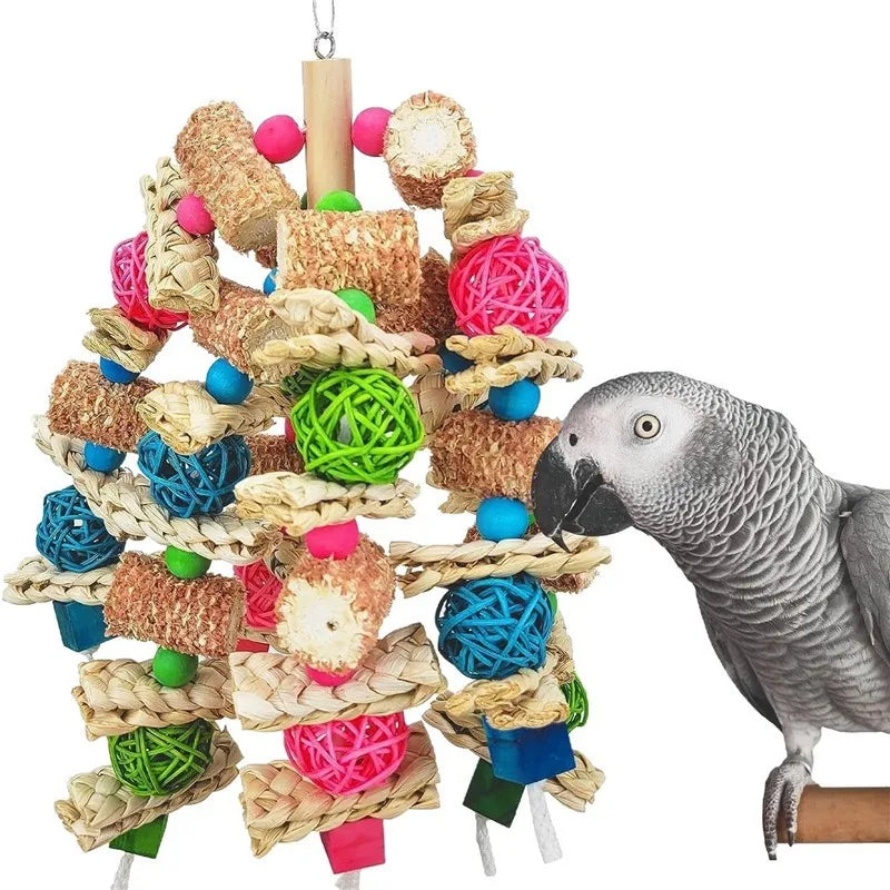 A gray parrot is perched on a natural wooden toy made of woven straw and wood pieces.