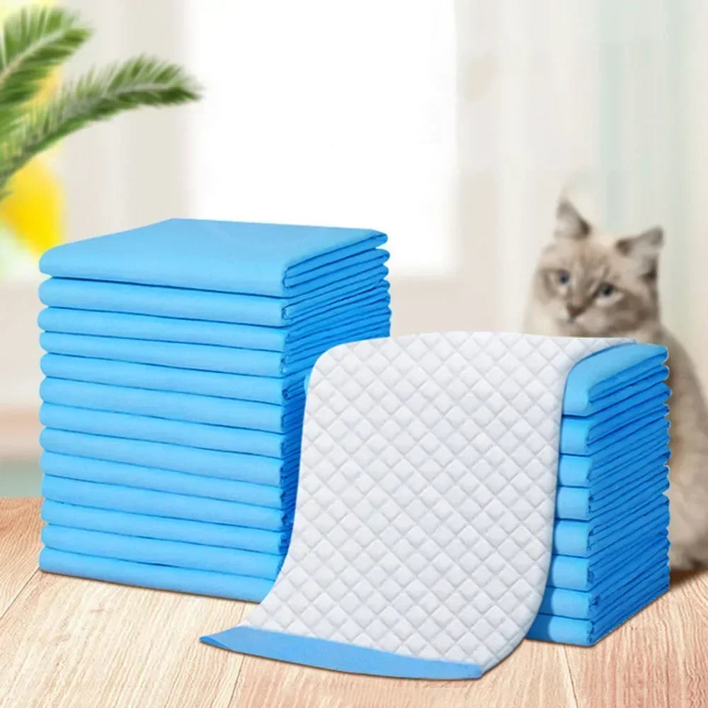 A stack of blue and white ultra-absorbent pet training pads on a wooden surface.