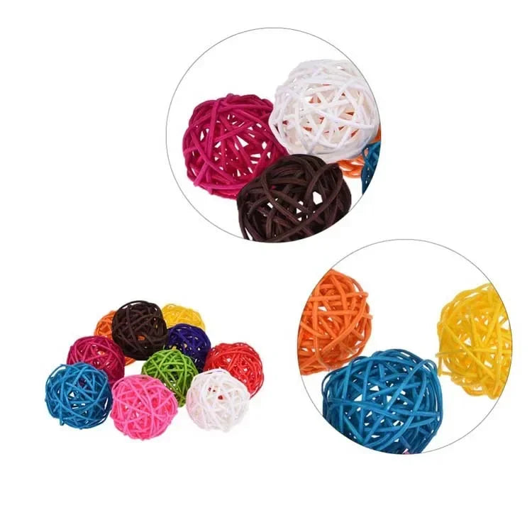 A collection of colorful natural rattan chewing balls for parrots in various shades of pink, red, brown, and yellow.