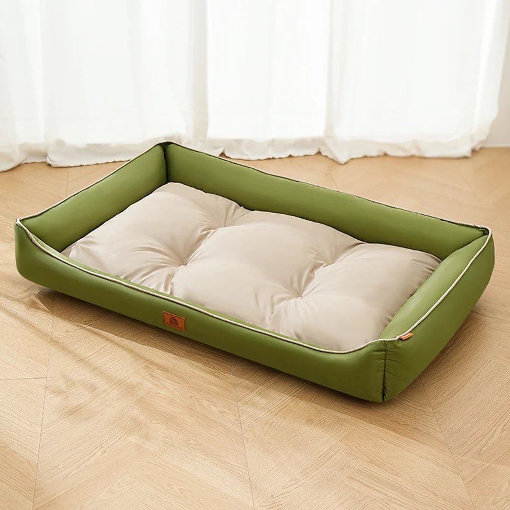 A rectangular, olive green corduroy sofa bed for pets is lying on a light wooden floor.