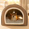 A tan pet bed with an arched entrance, featuring a fluffy dog resting inside.