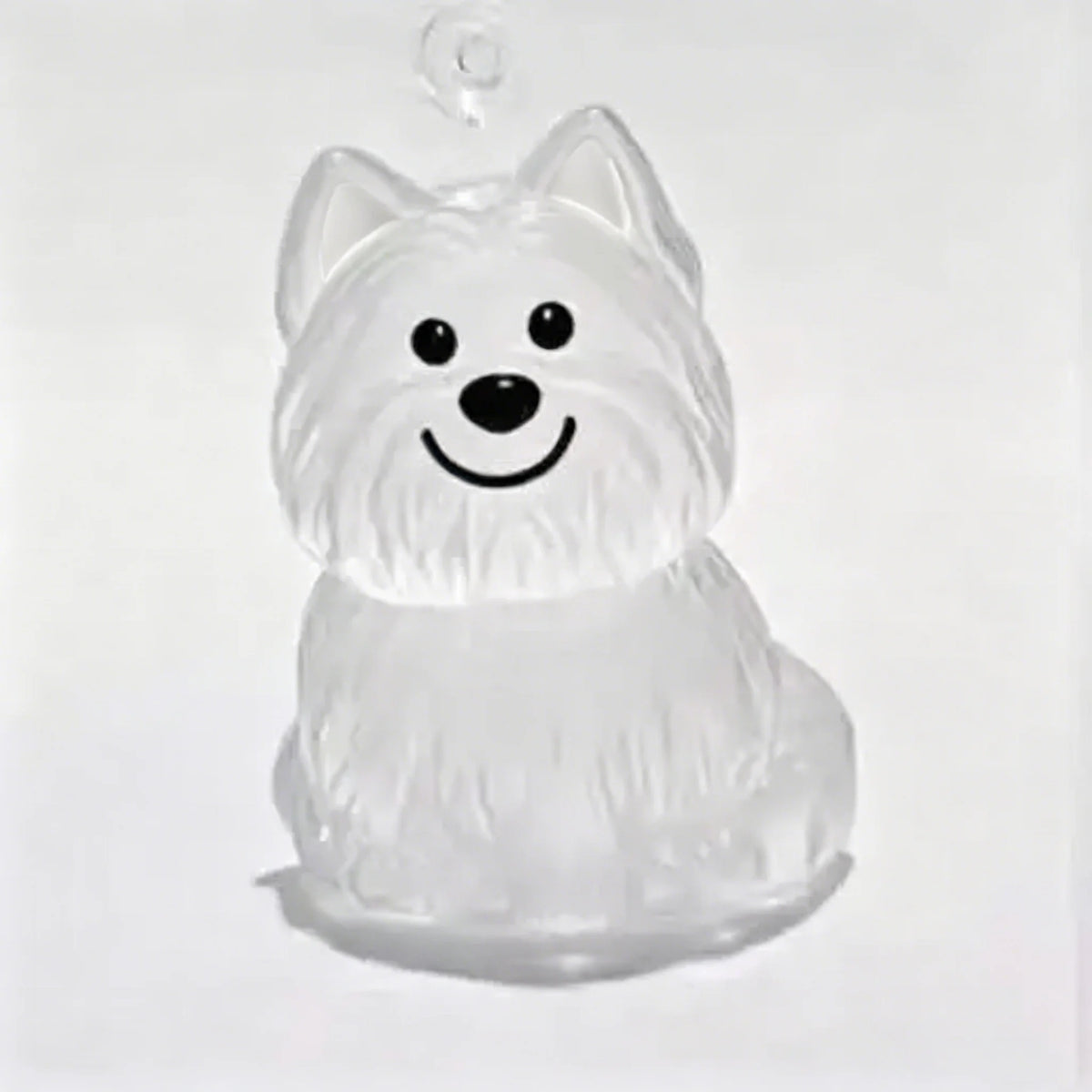 A clear silicone keychain shaped like a happy dog with a fluffy white coat.