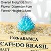 Blue artificial succulent plant with a conical shape growing in sand on a wooden surface